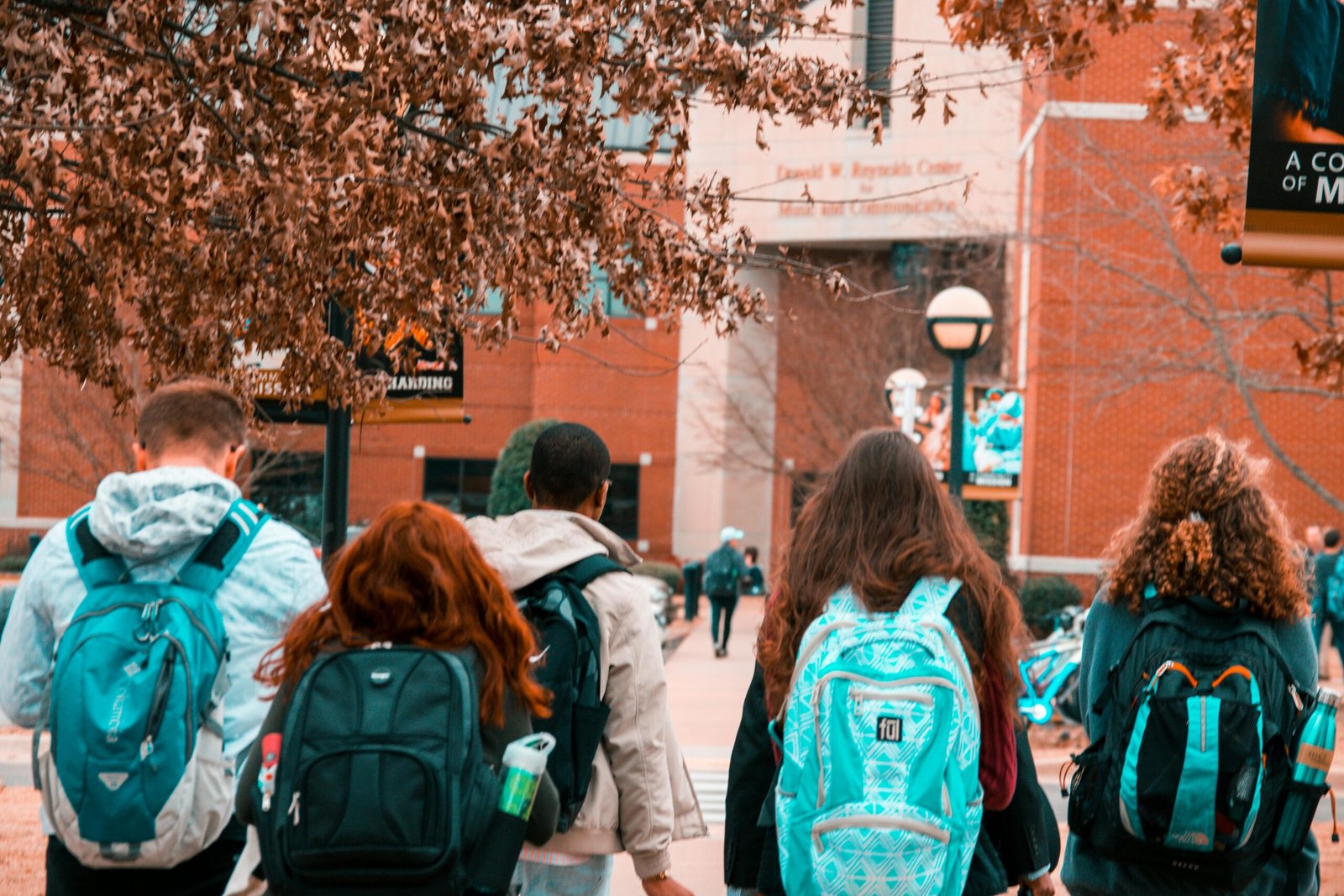 A group of college students with backpacks walking together outdoors on campus.